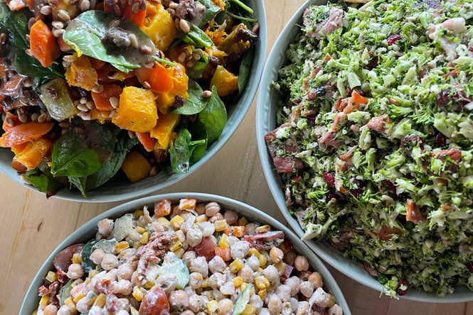 An extreme close up of three different salads in bowls.