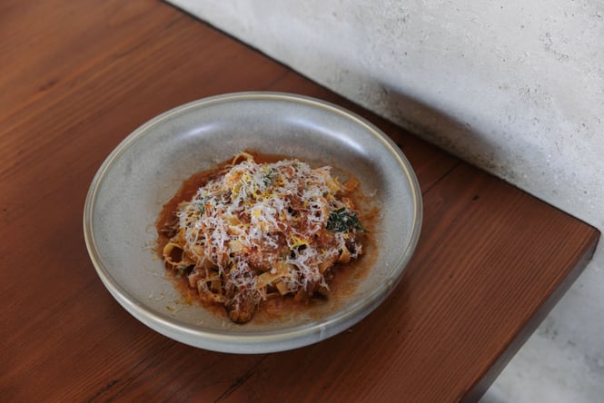 A photo of a plate of pasta with parmesan cheese sprinkled on top.