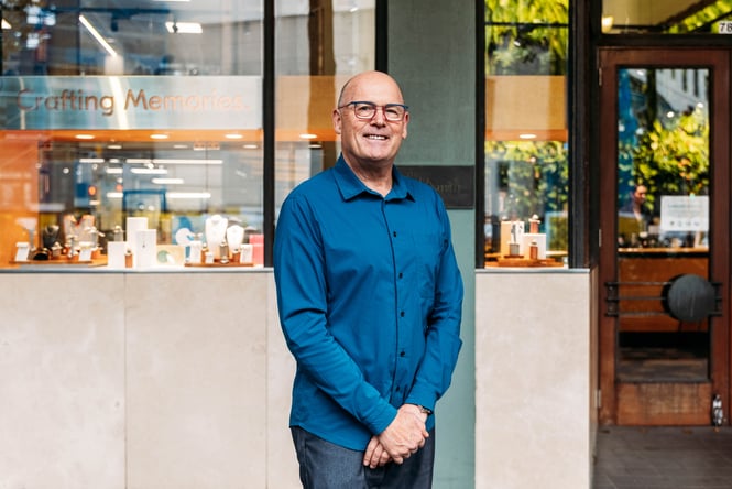 A man in a blue shirt smiling to camera.