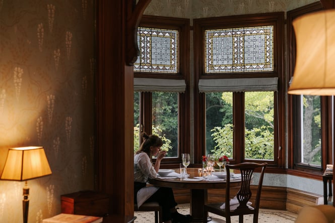 A woman eating soup in a little corner of the Otahuna Lodge lounge.
