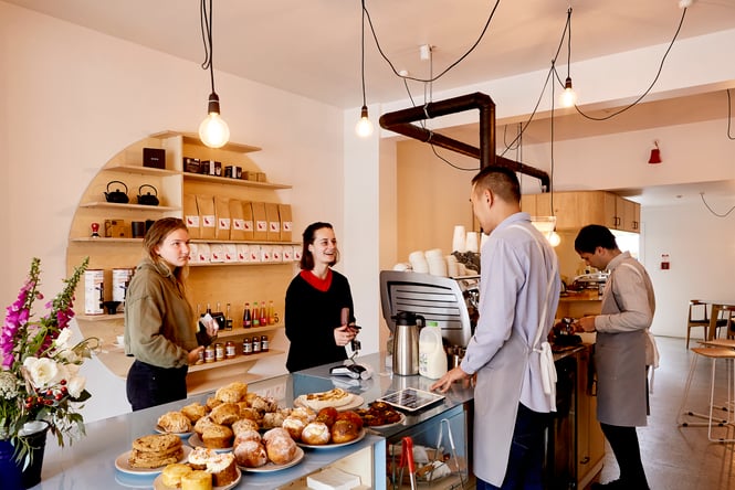 Customers chatting to stay inside a brightly lit cafe.