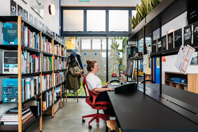 Jemma sitting at her laptop in her design studio JCDC in Palmerston North