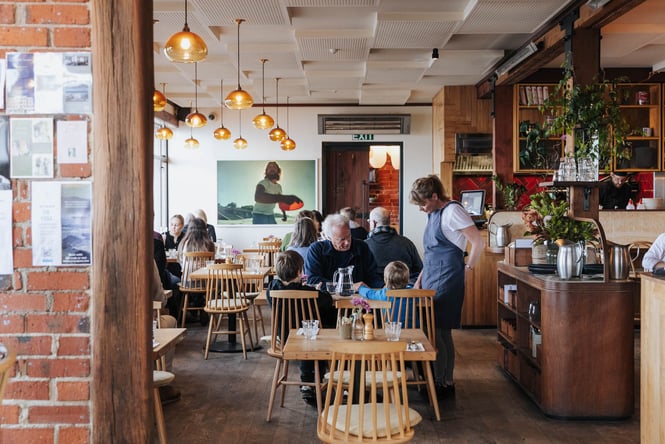 Waitress serving grandfather and his grandkids inside Italian restaurant and bar The Esplanade in St Clair