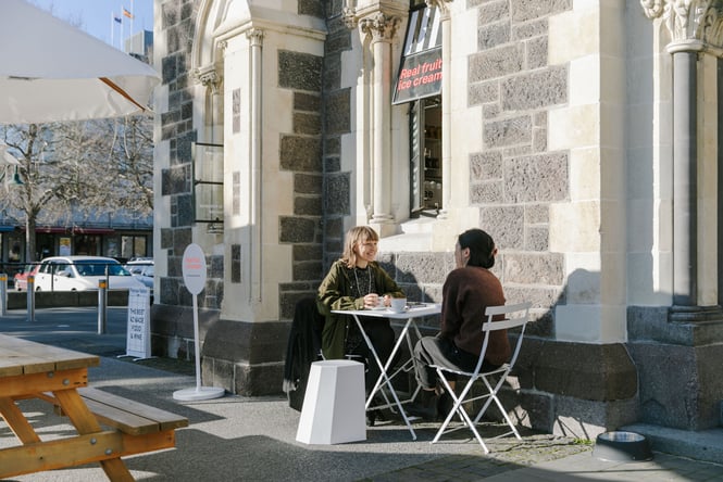 Two people sitting outside in the sunshine.