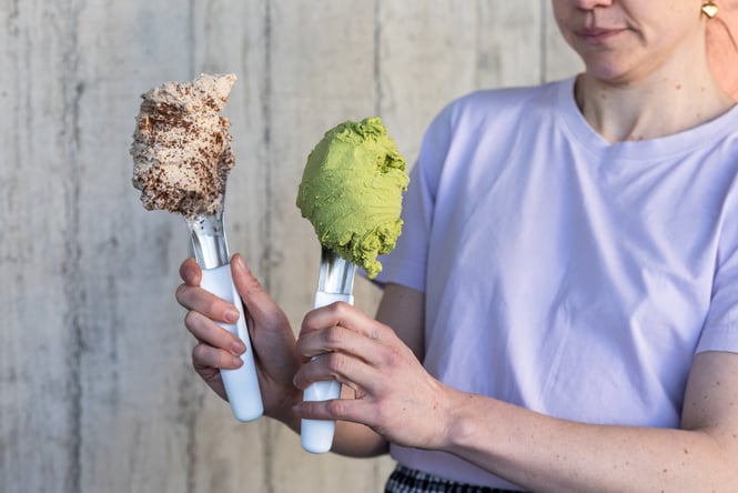 Shop assistant holding up two scoops of gelato from Paleta Gelateria.