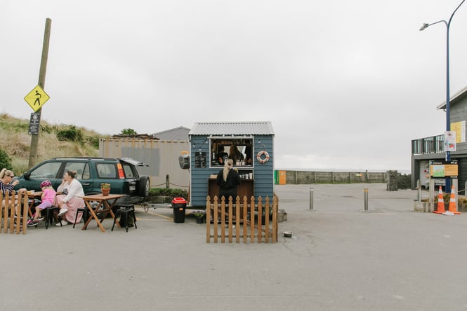 A view of a tiny blue coffee shed on a cloudy day.