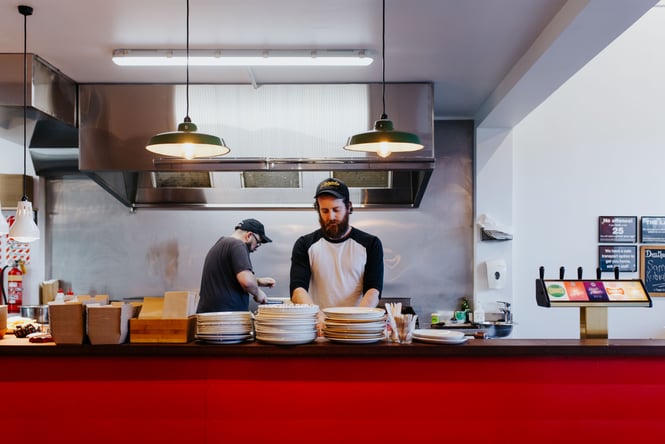 Two male chefs working in the kitchen at The Burger Joint.