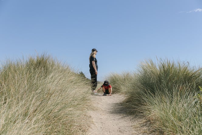 A woman and boy standing on top of a sand dune.