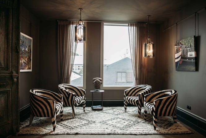 Black and white striped chairs inside a hotel room.