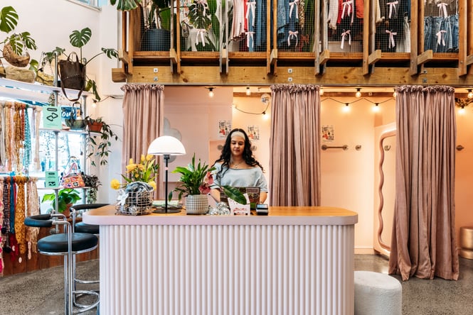 Shop assistant standing at the front counter of Preloved Charlies.