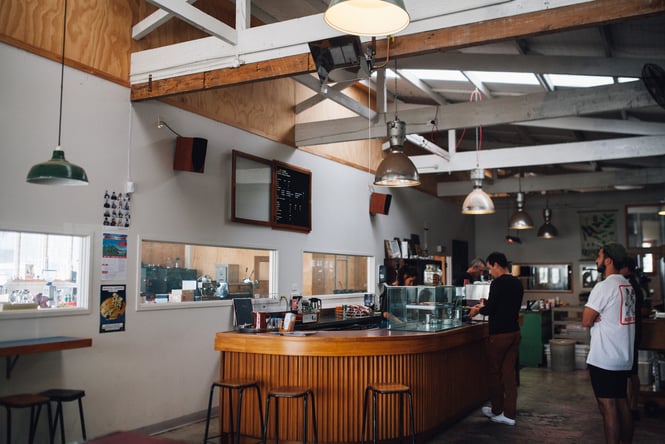 Overview of Rocket's industrial coffee shop and roastery with customers ordering at counter