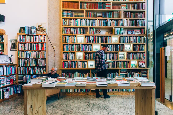 Man standing in front of high shelf of books at Browsers in Hamilton