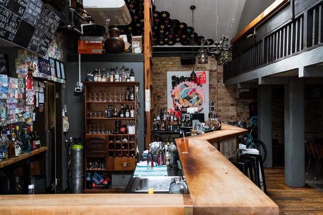 Overview of bar area at Wonder Horse in Hamilton with eclectic decor amongst the glassware and liquor