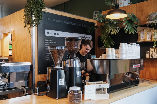 Barista behind the coffee machine at Common Ground Espresso.