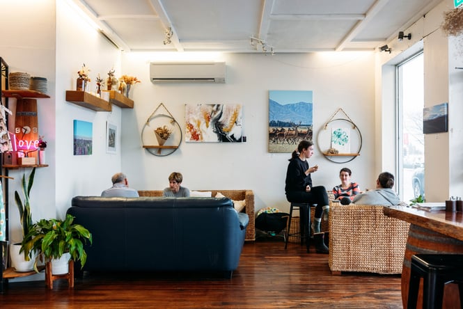 Customers sitting at tables and on couches in the dining area of Floral & Feast Kitchen.
