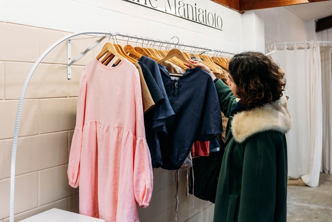 Customer browsing clothing rack at Lohi Linen.