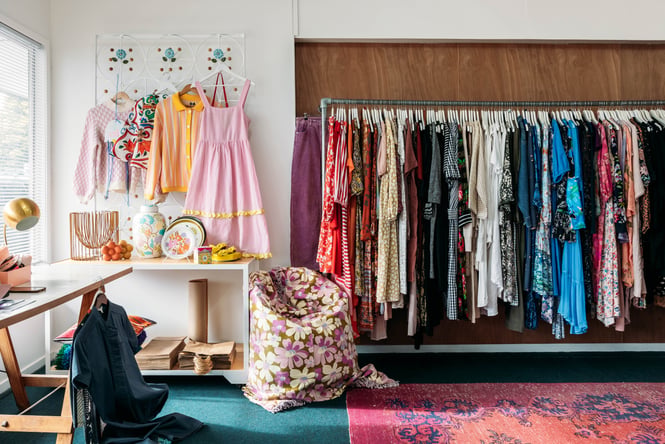 Colourful clothes on racks inside a retail store.