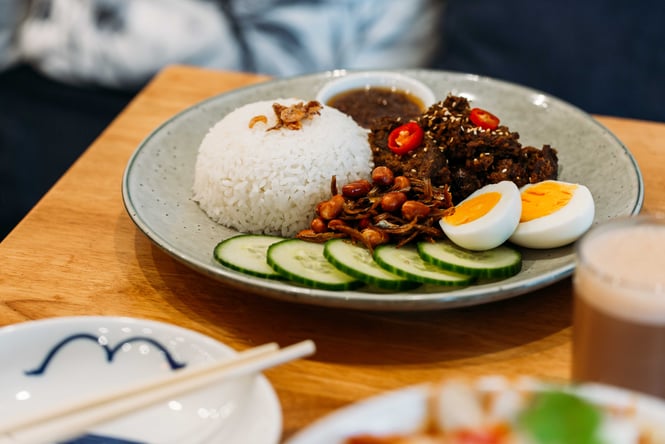 A plate of beef with a side of a boiled egg.