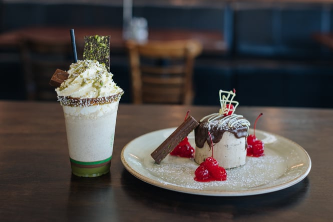 Milkshake and a dessert on a table.
