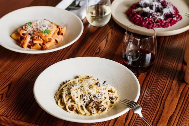 Plates of Italian food on a table at Andiamo Eatery.