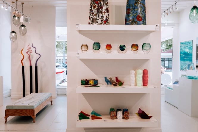 Glass artworks on display on shelving at Black Door Gallery.