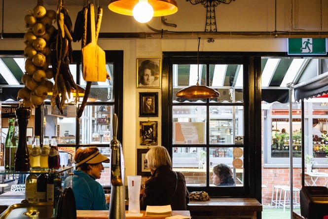 Two women dining inside an Italian restaurant.