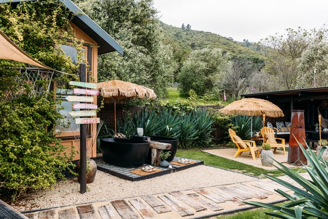 Outdoor chairs and tables set up beside Dreamscape Glamping.