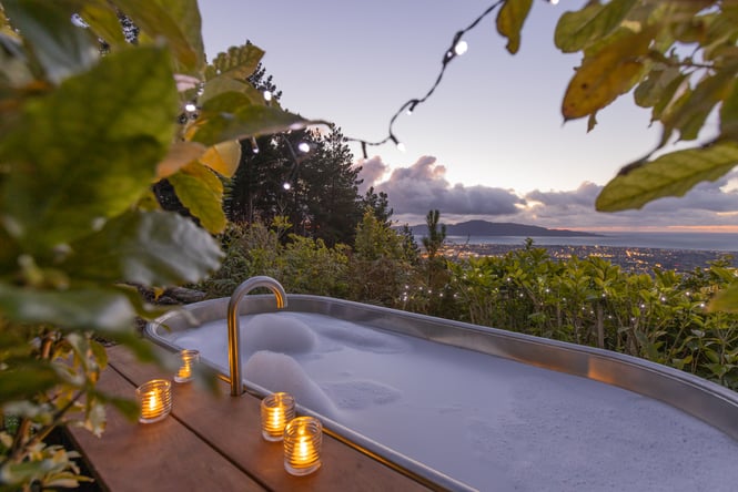 Hot tub with fairy lights and in the background is the coastline.