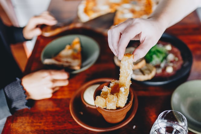 Close up of someone reaching for a polenta chip at Francesca's in Christchurch