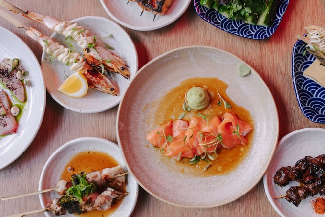 A flatlay of colourful plates of food on a table.