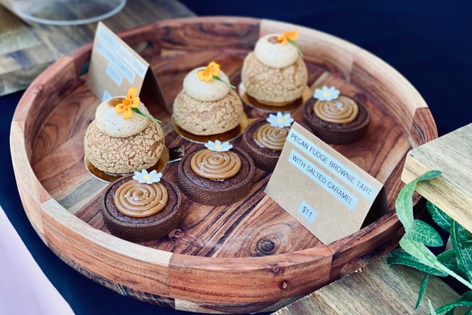 A collection of pastries laid out on a round wooden platter.