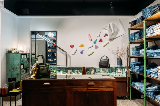 Simon Lewis art on the walls and stacks of jeans at Angel Divine.
