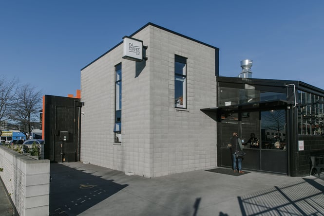 Concrete and black industrial exterior of C4 Coffee on Fitzgerald Ave