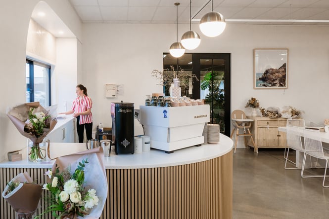 Cafe area at Addy & Lou with flower arrangements in front of coffee machine
