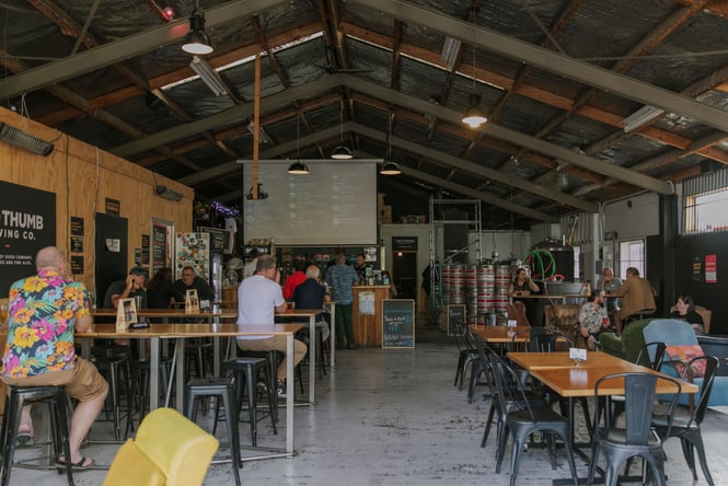 People drinking inside Two Thumb's warehouse brewery on Manchester Street