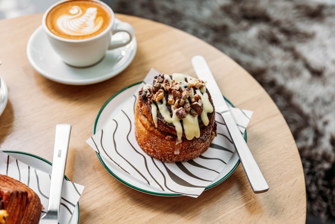A pastry is on the table with two coffees at Crumb Bakehouse.