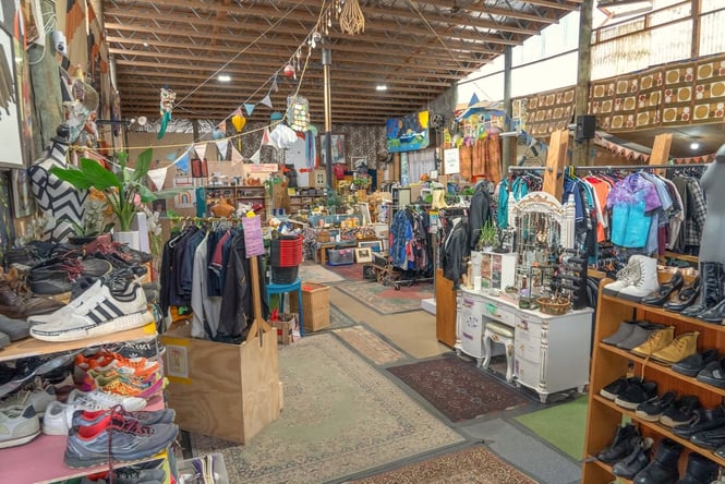 Shop floor of Wastebusters with racks of clothing and other items.