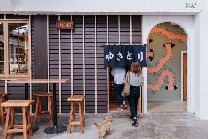 A woman walking towards the entrance to Bar Yoko in The Welder.