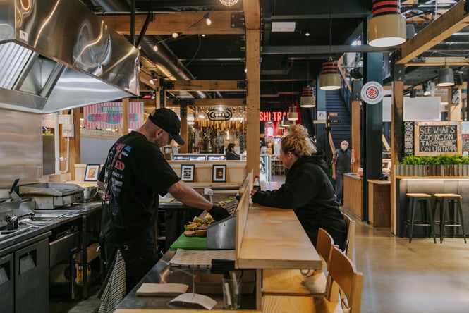 A customer and a staff member at the kitchen slash bar area.