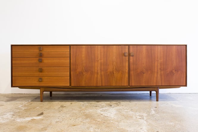 A wooden buffet cabinet with sliding draws.