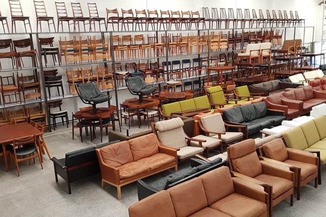 Rows of vintage chairs lined up inside a warehouse.