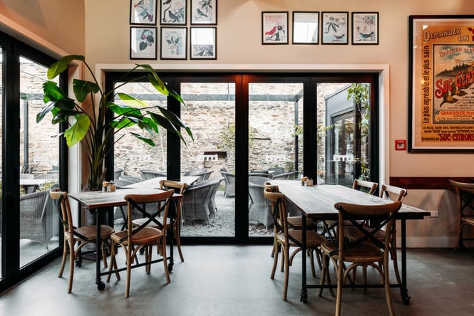 The dining room with outside seating in the background at The Merchant of Clyde.