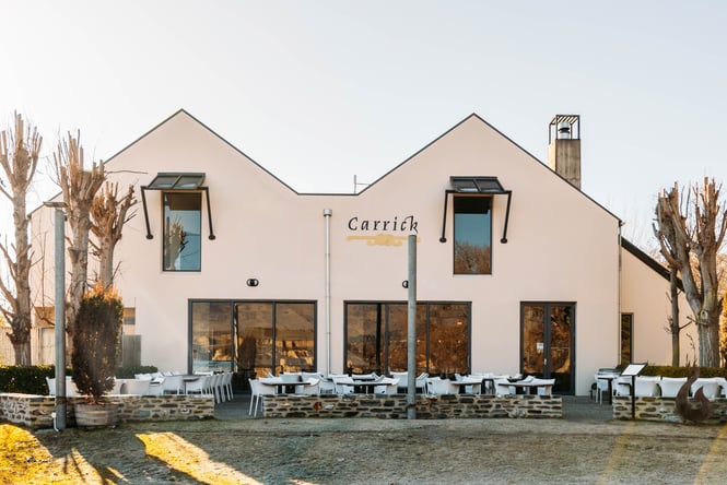 Outdoor tables and chairs on the patio in front of the building at Carrick Winery.