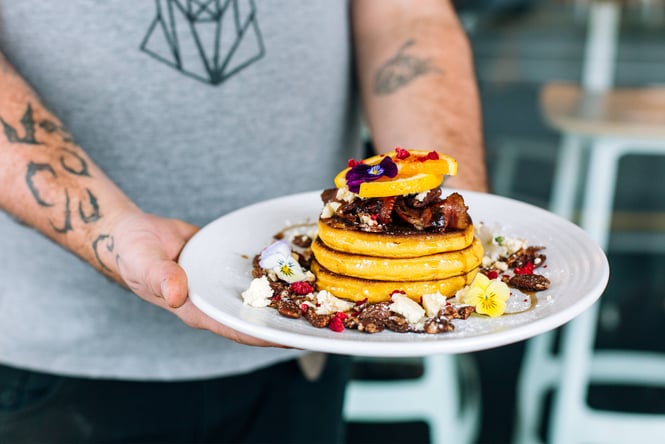 A man holding carrot pancakes from Neo Cafe in Wellington.