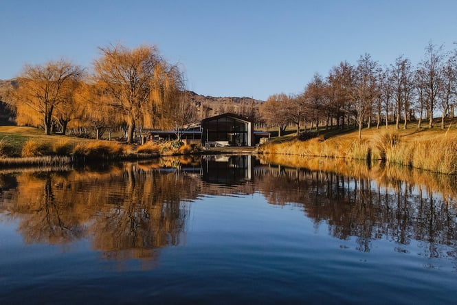 A shed at the edge of a lake.