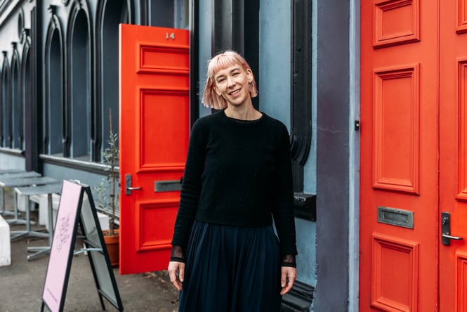 A woman with a short bob smiling to camera.