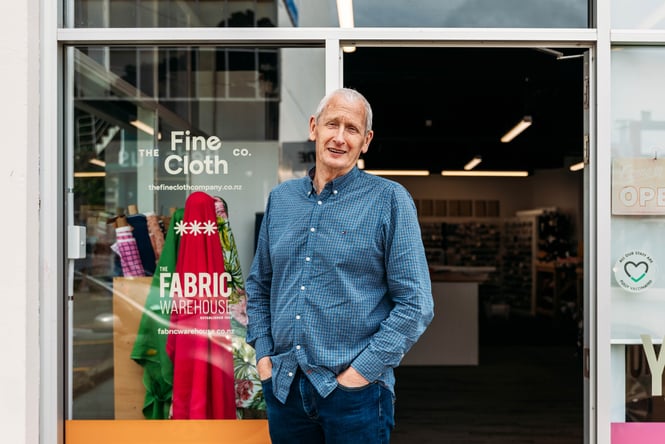 A man outside a shop looking at camera.