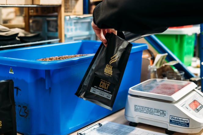 Dark Horse coffee bean packet being filled up.