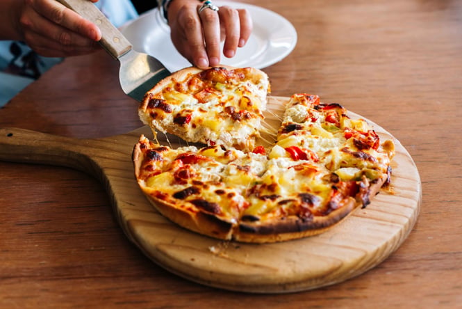 A slice of pizza being pulled out.