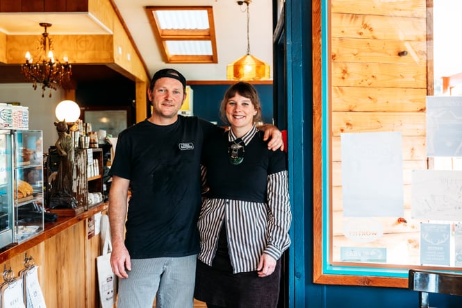 A man and woman posing for camera inside The Duke's Roadhouse.
